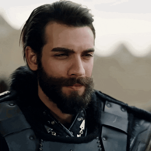 a man with a beard is wearing armor