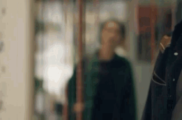 a blurry picture of a man standing in front of a mirror in a room .