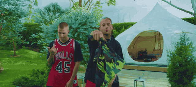 a man in a bulls 45 jersey stands next to another man
