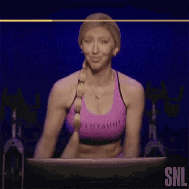 a woman in a lotaunt sports bra is giving a thumbs up