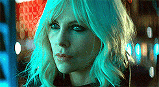 a close up of a woman 's face with blue hair and blue eyes .