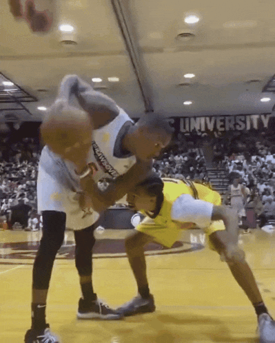 a basketball game is being played in front of a university banner