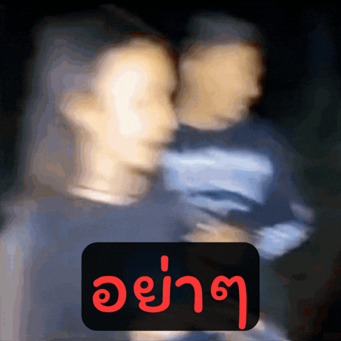 a blurry picture of a man and woman with a sign that says ' a ' in red letters