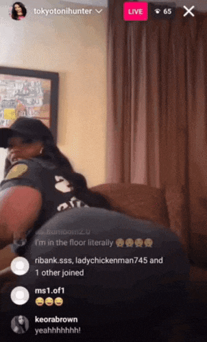 a woman is sitting on a couch in front of a screen that says " live "