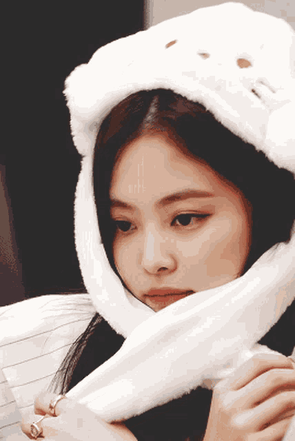 a close up of a woman wearing a white furry hat