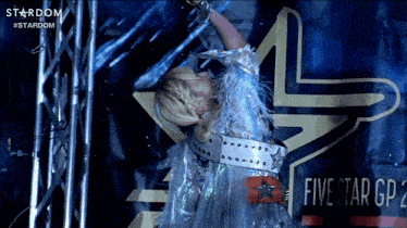 a woman is dancing in front of a sign that says five star gp