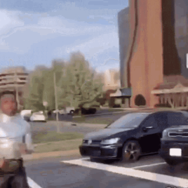 a man in a white shirt is running down a street in front of a building