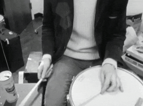 a man is playing a snare drum with a can of mrs. potato chips in the foreground