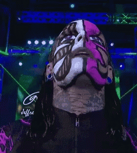 a man with a pink mask on his face is looking at the camera