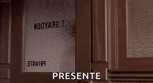 a woman is standing in front of a door with the word presente written on the door .