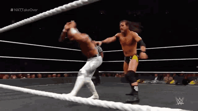 two wrestlers are wrestling in a ring with the hashtag # nxt takeover