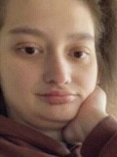 a close up of a woman 's face with a hand on her chin