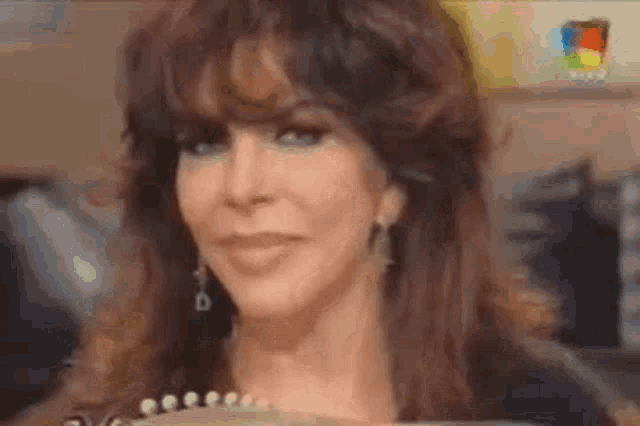 a close up of a woman 's face with long brown hair and earrings making a funny face .