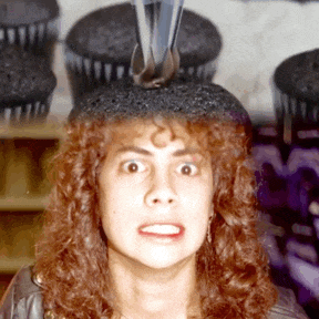 a woman with a cupcake on her head is making a face