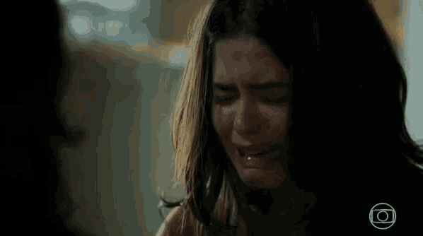 a close up of a woman crying with her eyes closed and her mouth open .