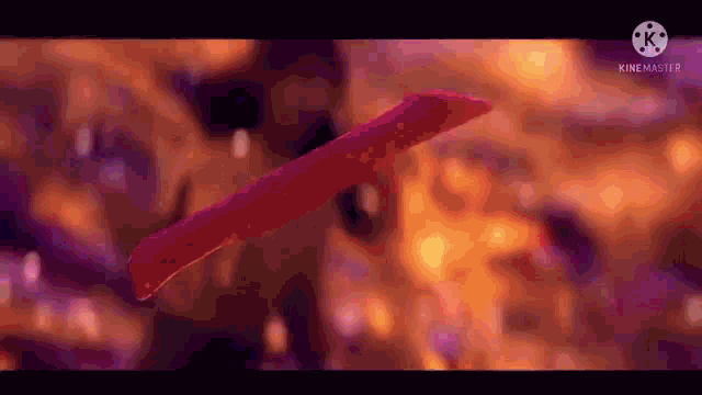 a red object is floating in the air in a blurry picture .