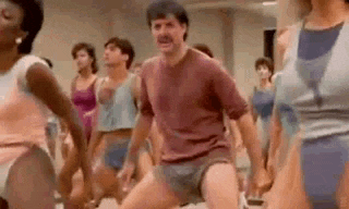 a man is dancing in a gym with a group of people .