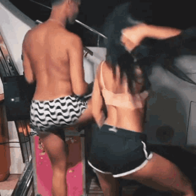a man and a woman dancing on a boat at night