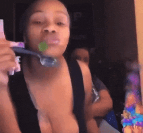 a woman is brushing her teeth with a toothbrush in her mouth