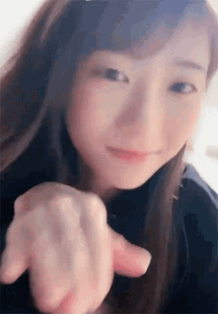 a close up of a woman 's face pointing at the camera