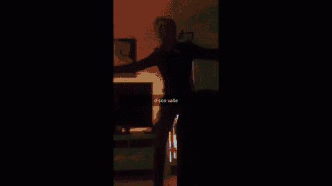 a man is dancing in a dark room with the words disco valley written on the screen .