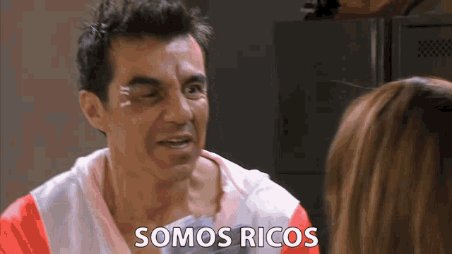 a man with a bandage on his eye is talking to a woman who says somos ricos