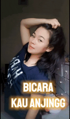 a woman in a blue shirt with the words " bicara kau anjingg " on the bottom