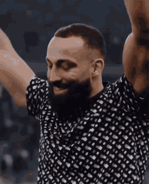 a man with a beard wearing a black and white shirt