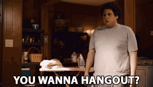 a man standing in front of an ironing board with the words you wanna hangout