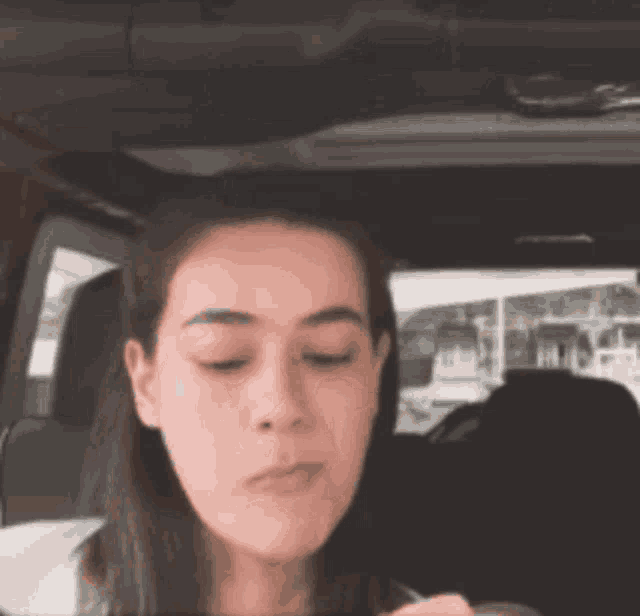 a woman is sitting in the back seat of a car