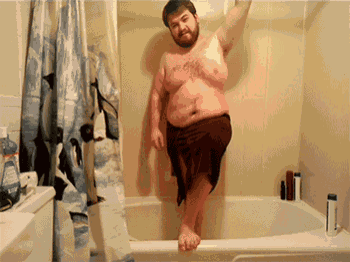 a man in a bathtub with a shower curtain that says penguins on it