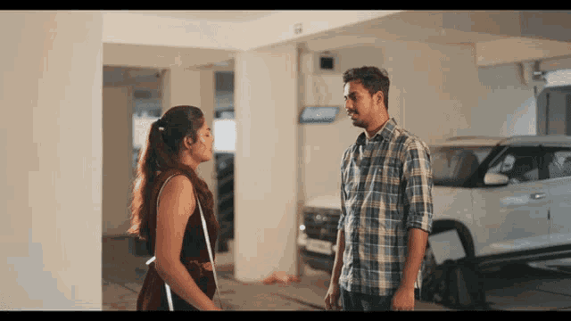a man and a woman are standing next to each other in a garage