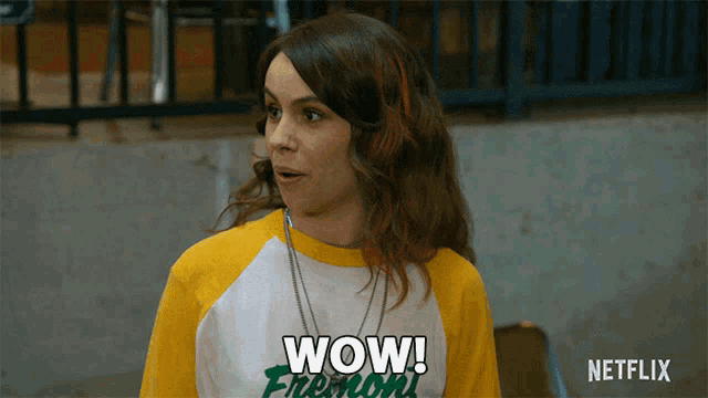 a woman is wearing a yellow and white shirt that says wow
