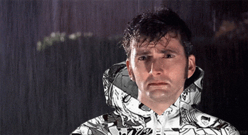 a man is standing in the rain wearing a hoodie