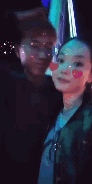 a man and a woman are standing next to each other in a dark room .