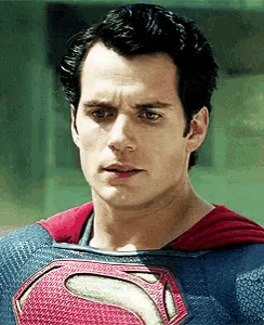 a man in a superman costume is looking at the camera