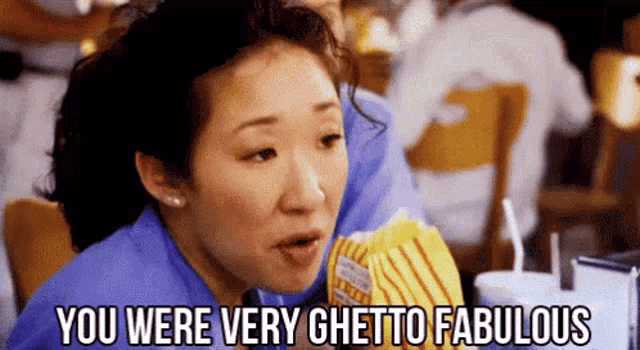 a woman is sitting at a table in a restaurant eating popcorn and saying `` you were very ghetto fabulous `` .