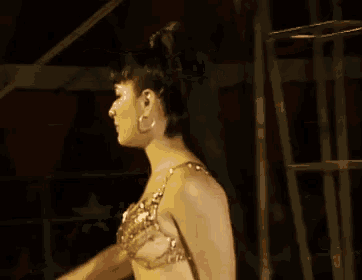 a woman in a sequined bra is smiling with her arms in the air