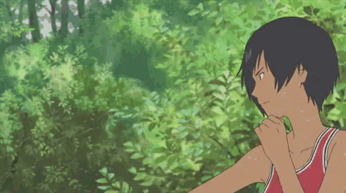 a boy in a red shirt is standing in the woods