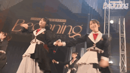 a group of girls are performing in front of a banner that says beginning