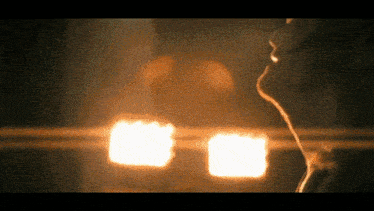 a close up of a person 's face with a blurry background of lights