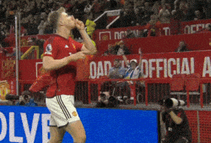 a soccer player is celebrating a goal in front of a sign that says official