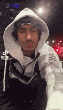 a man wearing a bandana and a white hoodie has a tiktok sticker on his face
