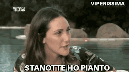 a woman is sitting in front of a pool with the words stanotte ho pianto written on the screen .