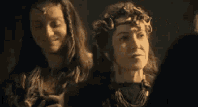a couple of women are standing next to each other in a dark room .