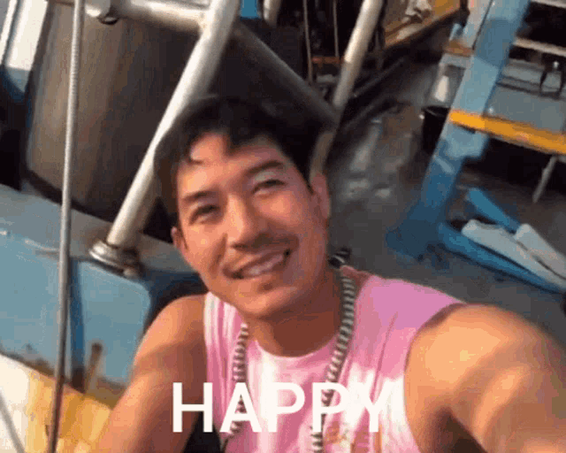 a man in a pink tank top is smiling and the word happy is visible