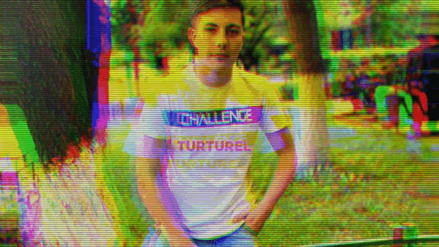 a man wearing a shirt that says challenge torture is standing in a park