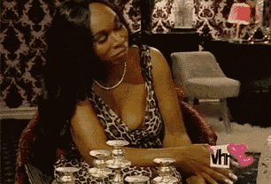 a woman in a leopard print dress is sitting at a table with candles and a sign that says vh1 on it