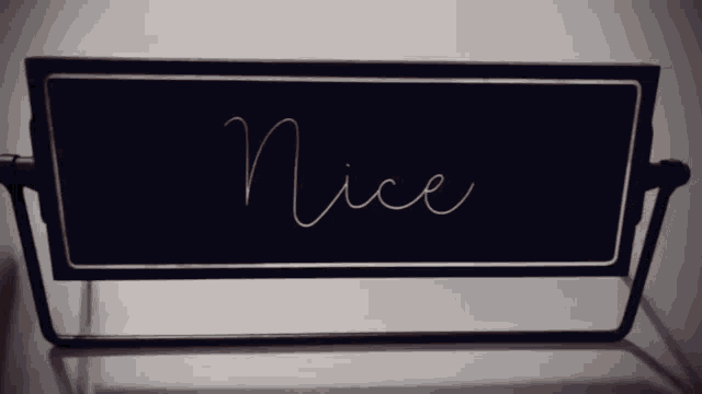 a black and gold sign that says nice