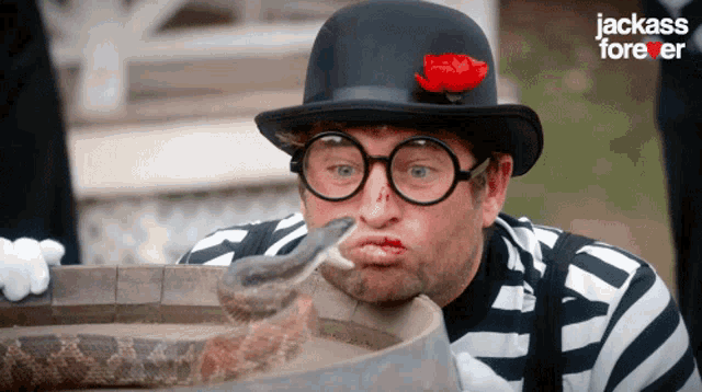a man with a snake in his mouth and the words jackass forever in the corner